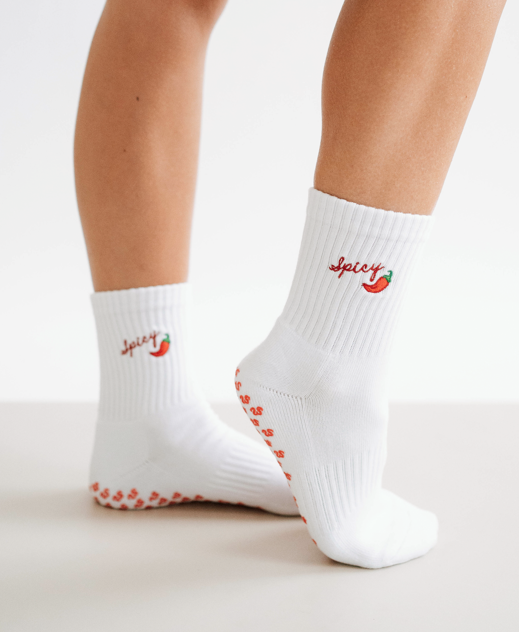 White crew grip socks with 'Spicy' and chili pepper design